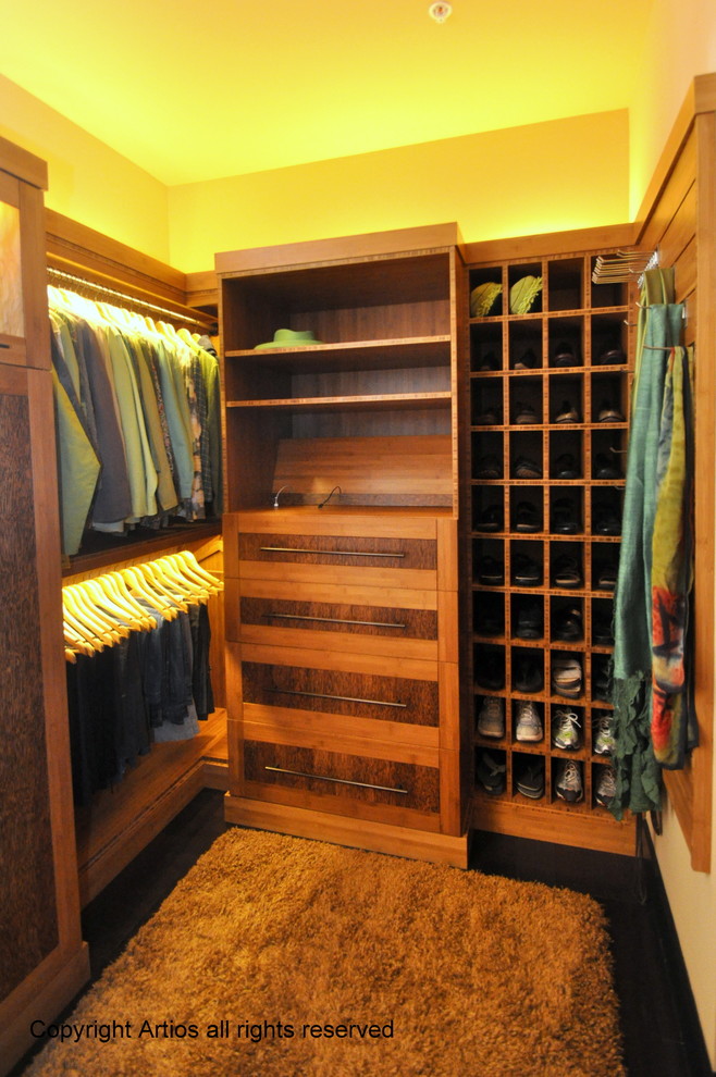 This is an example of a large contemporary gender-neutral walk-in wardrobe in Orlando with shaker cabinets, medium wood cabinets and dark hardwood floors.