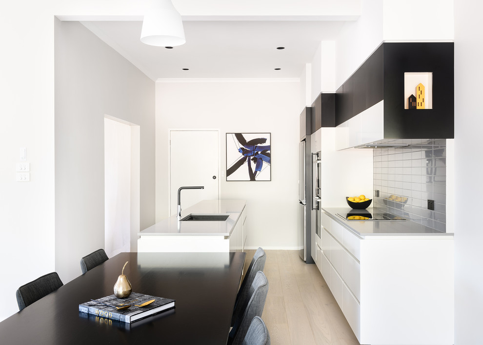 Design ideas for a contemporary galley eat-in kitchen in Hobart with an undermount sink, flat-panel cabinets, white cabinets, grey splashback, stainless steel appliances, light hardwood floors, a peninsula, beige floor and grey benchtop.