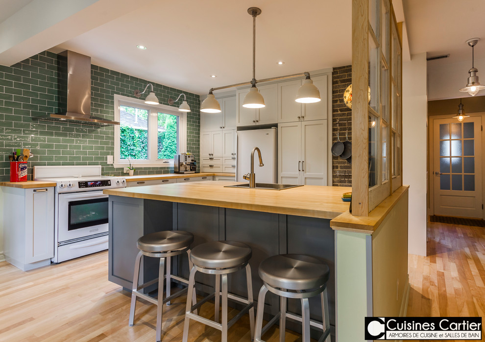 Large transitional galley medium tone wood floor open concept kitchen photo in Montreal with a single-bowl sink, shaker cabinets, gray cabinets, wood countertops, green backsplash, ceramic backsplash, white appliances and an island