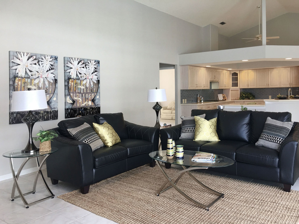 This is an example of a mid-sized contemporary open concept family room in Tampa with grey walls, ceramic floors, beige floor, a standard fireplace, a stone fireplace surround and a wall-mounted tv.