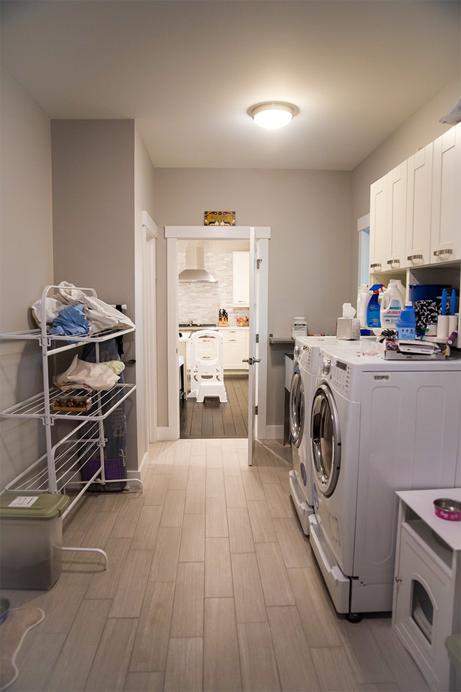 Design ideas for a large country dedicated laundry room in Burlington with light hardwood floors and a side-by-side washer and dryer.