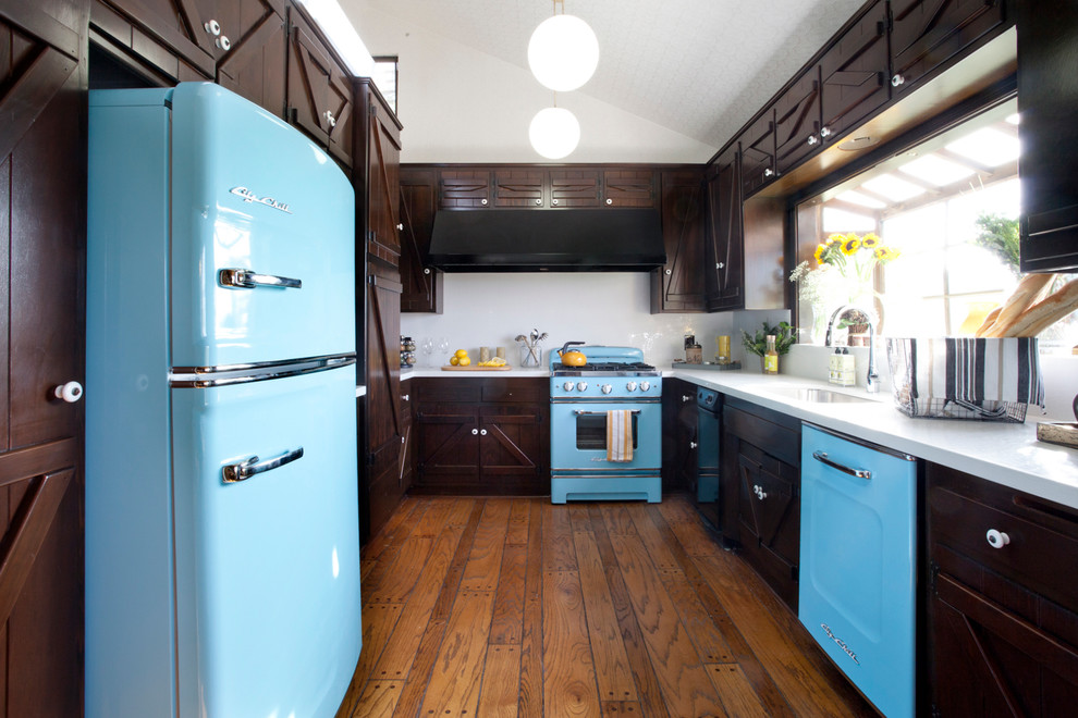 This is an example of a country u-shaped separate kitchen in New York with dark wood cabinets, white splashback and coloured appliances.