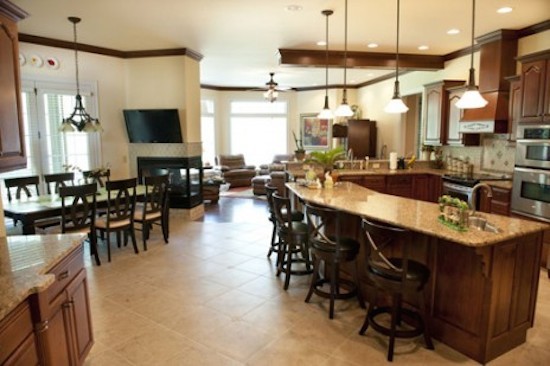 Large galley eat-in kitchen photo with a drop-in sink, beaded inset cabinets, medium tone wood cabinets, beige backsplash, stainless steel appliances and an island