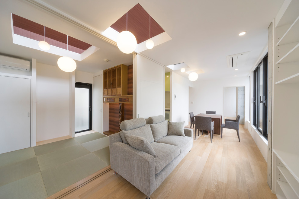 Photo of a mid-sized contemporary open concept living room in Tokyo with white walls, light hardwood floors and beige floor.
