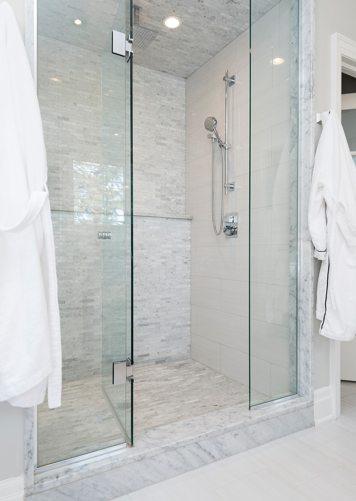 Inspiration for a large transitional master bathroom in Toronto with an undermount sink, recessed-panel cabinets, white cabinets, marble benchtops, a drop-in tub, an alcove shower, a one-piece toilet, white tile, mosaic tile, white walls and porcelain floors.
