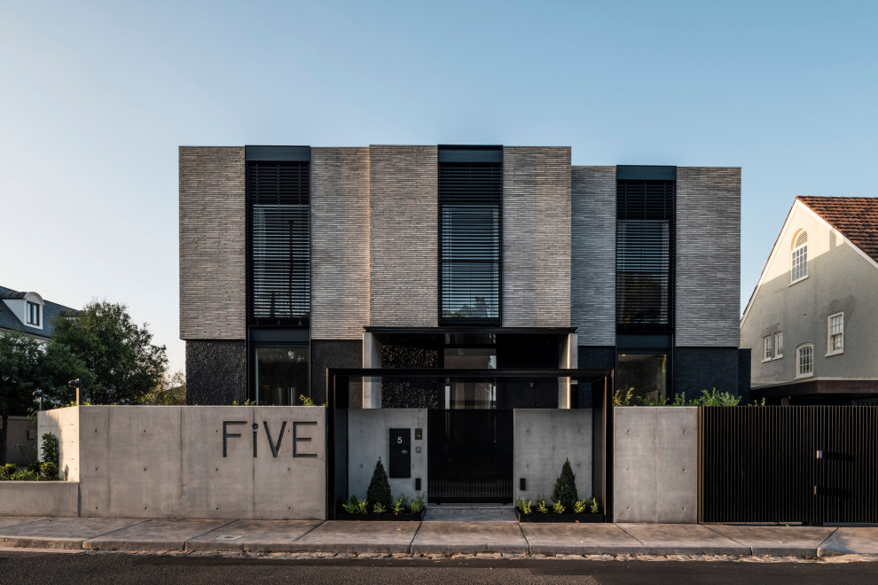 Ejemplo de fachada de casa gris minimalista grande de dos plantas con revestimiento de ladrillo