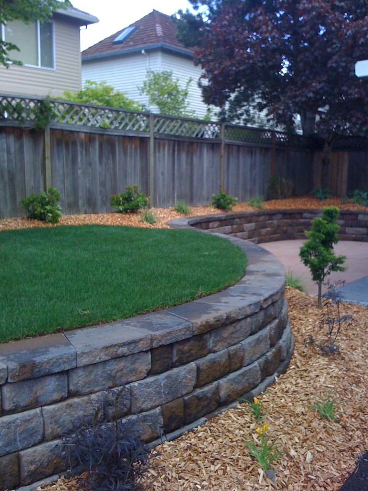 Photo of a small traditional backyard full sun garden for spring in Portland with a retaining wall and brick pavers.