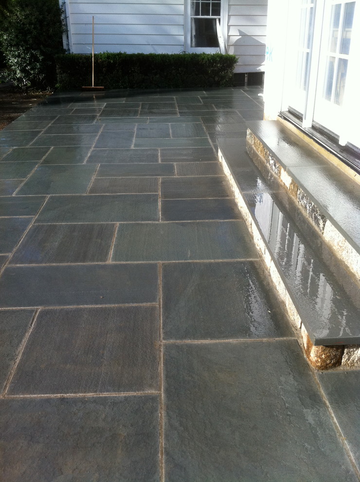 Photo of a large traditional backyard patio in New York with no cover and natural stone pavers.