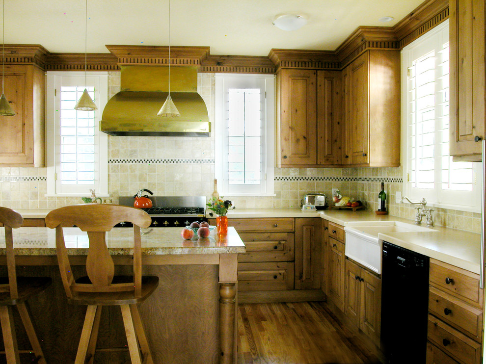 Enclosed kitchen - mid-sized craftsman l-shaped medium tone wood floor enclosed kitchen idea in Denver with a farmhouse sink, raised-panel cabinets, medium tone wood cabinets, granite countertops, beige backsplash, stone tile backsplash, black appliances and beige walls