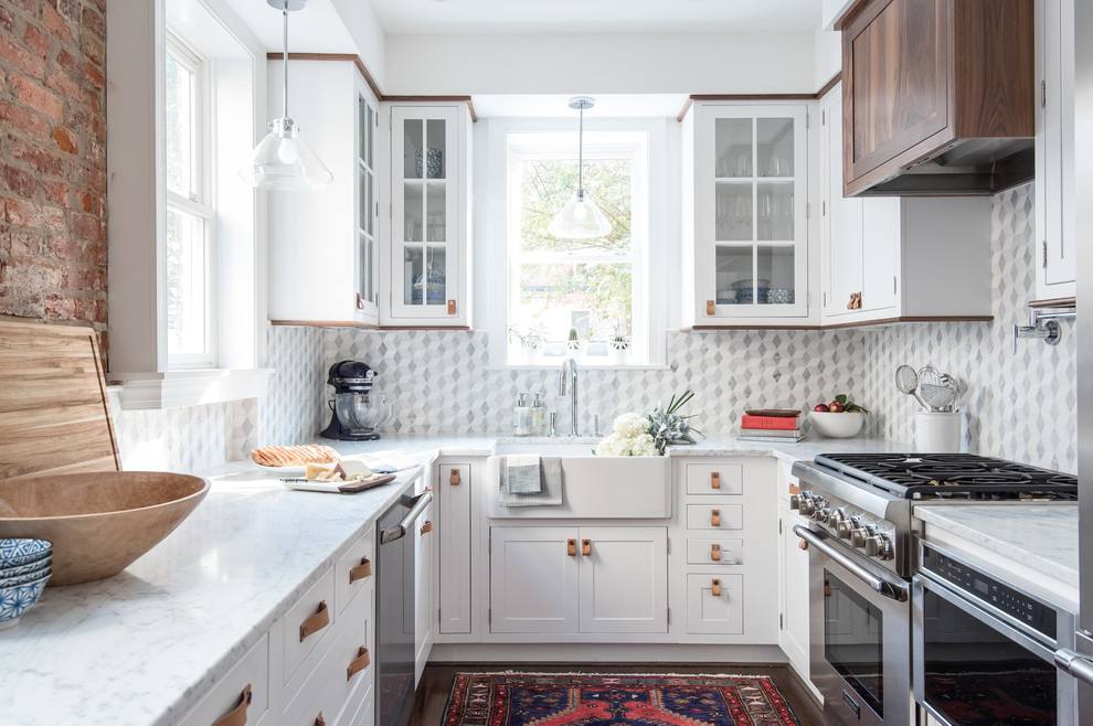 Inspiration for a transitional u-shaped kitchen in DC Metro with a farmhouse sink, shaker cabinets, white cabinets, stainless steel appliances, dark hardwood floors and no island.
