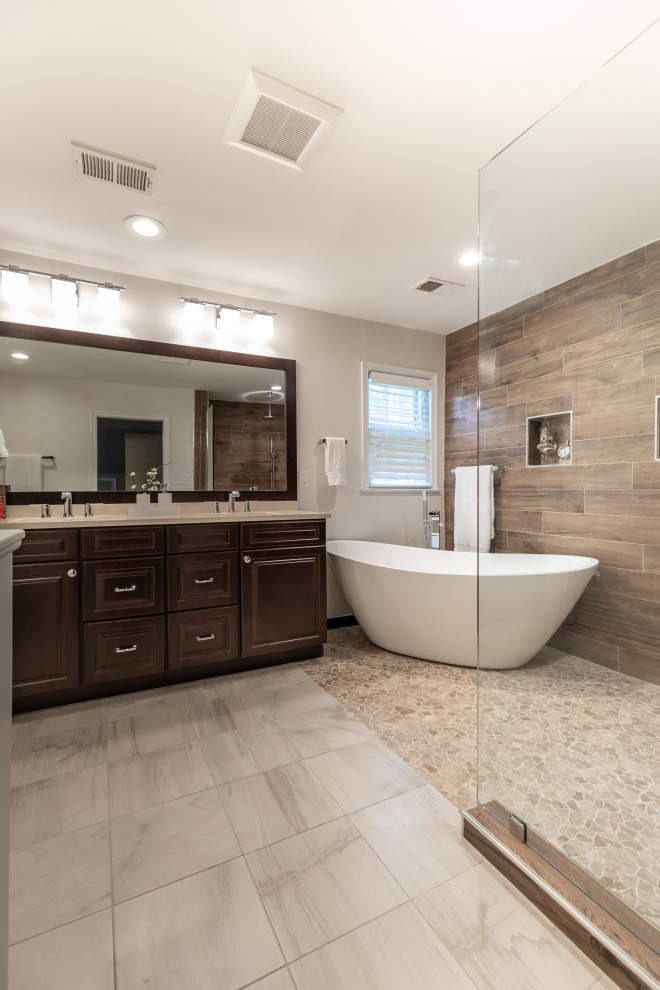 Modern inredning av ett mellanstort vit vitt en-suite badrum, med bruna skåp, ett fristående badkar, en dusch/badkar-kombination, en toalettstol med hel cisternkåpa, brun kakel, grå väggar, ett undermonterad handfat, grått golv och med dusch som är öppen