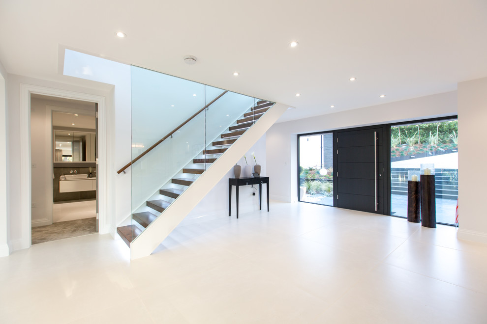 This is an example of a contemporary entryway in Dorset with porcelain floors, a single front door and a black front door.