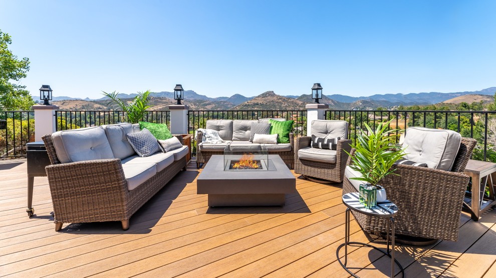 Example of a large transitional backyard deck design with a fire pit and no cover
