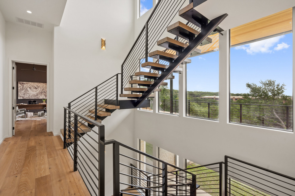 Ejemplo de escalera en U contemporánea de tamaño medio con contrahuellas de metal y barandilla de madera