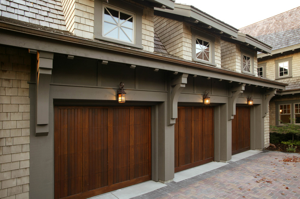 This is an example of a large traditional attached three-car garage in Minneapolis.