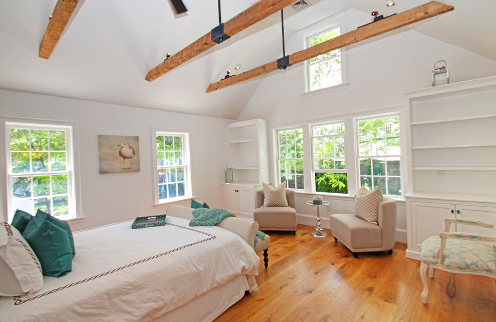 Photo of a mid-sized transitional guest bedroom in Boston with white walls, light hardwood floors and brown floor.