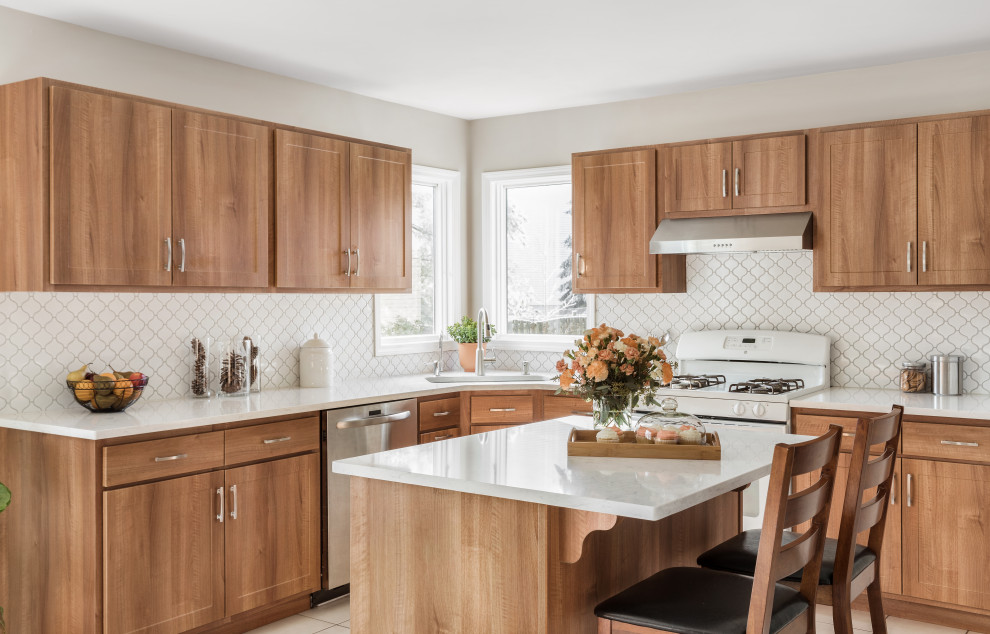 Photo of a large transitional l-shaped eat-in kitchen in Philadelphia with a single-bowl sink, medium wood cabinets, quartzite benchtops, white splashback, ceramic splashback, with island, white floor, white benchtop, flat-panel cabinets, stainless steel appliances and cement tiles.