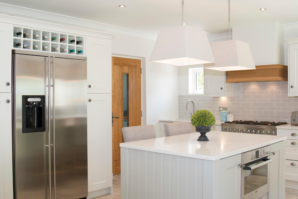 Inspiration for a large traditional u-shaped kitchen/diner with a built-in sink, recessed-panel cabinets, beige cabinets, quartz worktops, beige splashback, ceramic splashback, stainless steel appliances, travertine flooring, an island and beige floors.