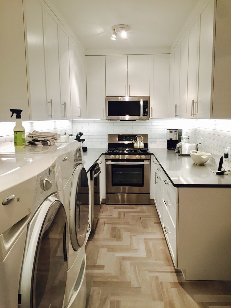 Inspiration for a small contemporary u-shaped separate kitchen in New York with an undermount sink, shaker cabinets, white cabinets, quartz benchtops, white splashback, ceramic splashback, stainless steel appliances, porcelain floors, no island and beige floor.