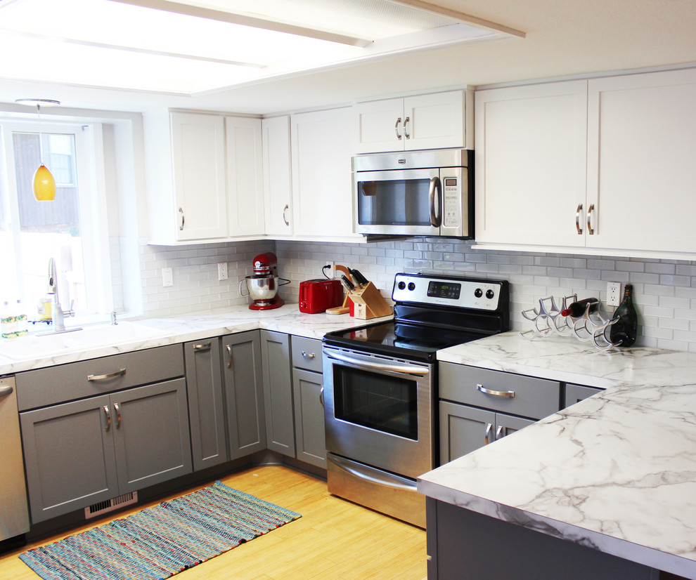 Inspiration for a mid-sized transitional u-shaped bamboo floor eat-in kitchen remodel in Boise with a drop-in sink, shaker cabinets, gray cabinets, laminate countertops, white backsplash, glass tile backsplash and stainless steel appliances