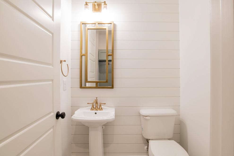 Gästetoilette mit weißen Schränken, weißer Wandfarbe, freistehendem Waschtisch und Holzdielenwänden in Sonstige