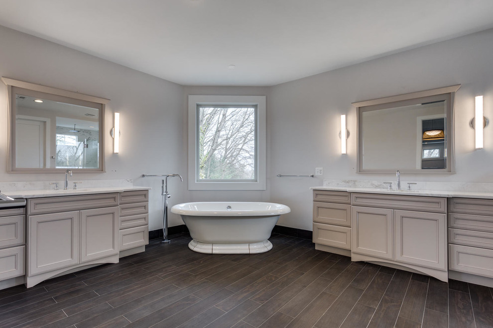 Freestanding bathtub - large transitional master brown tile and stone tile ceramic tile freestanding bathtub idea in DC Metro with recessed-panel cabinets, gray cabinets, gray walls, a drop-in sink and granite countertops