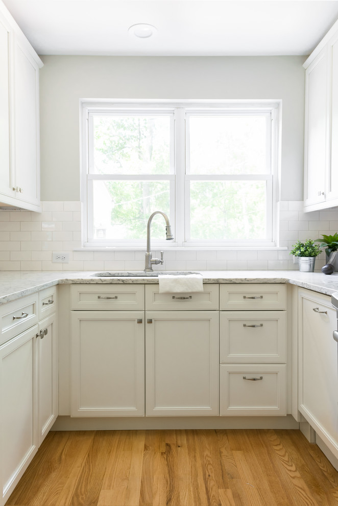 Design ideas for a small modern galley separate kitchen in St Louis with beaded inset cabinets, white cabinets, marble benchtops, white splashback, subway tile splashback and with island.