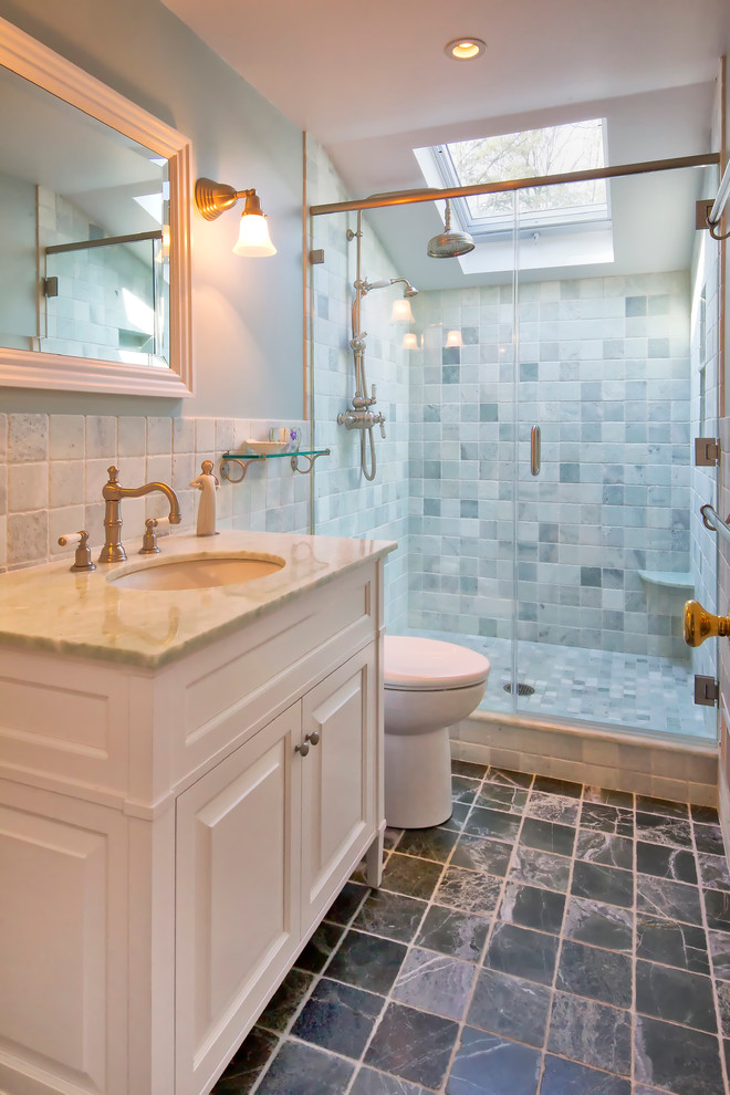 Design ideas for a traditional bathroom in New York with raised-panel cabinets, white cabinets, an alcove shower, a one-piece toilet, white tile, marble, blue walls, marble floors, an undermount sink, marble benchtops, black floor, a hinged shower door and green benchtops.