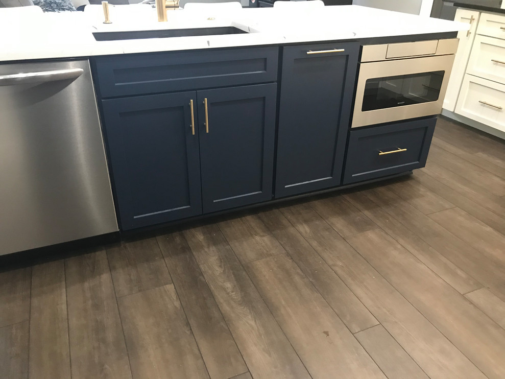 Open concept kitchen - huge transitional l-shaped vinyl floor and brown floor open concept kitchen idea in Baltimore with an undermount sink, shaker cabinets, white cabinets, quartz countertops, white backsplash, marble backsplash, stainless steel appliances, an island and multicolored countertops
