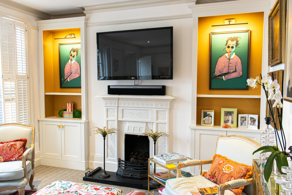 This is an example of a mid-sized traditional living room in Dorset with orange walls, carpet, a standard fireplace, a stone fireplace surround, a wall-mounted tv and beige floor.