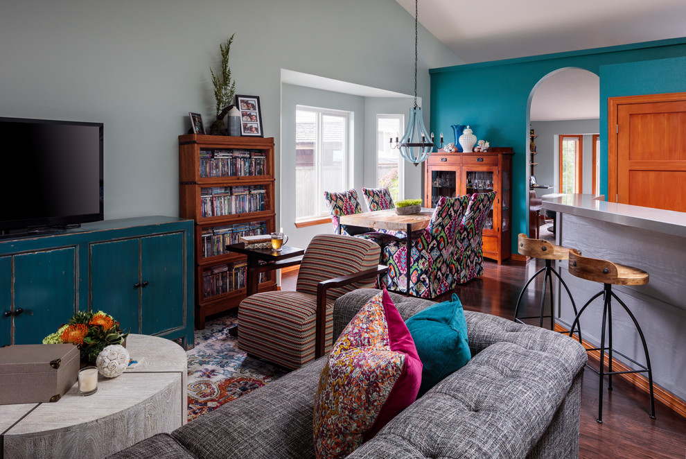 This is an example of a small eclectic open concept living room in Portland with a home bar, multi-coloured walls, dark hardwood floors, no fireplace, a freestanding tv and brown floor.
