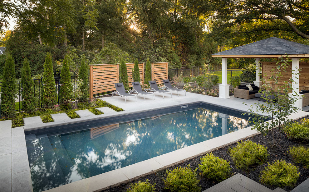Inspiration for a mid-sized contemporary backyard rectangular lap pool in Toronto with concrete slab.