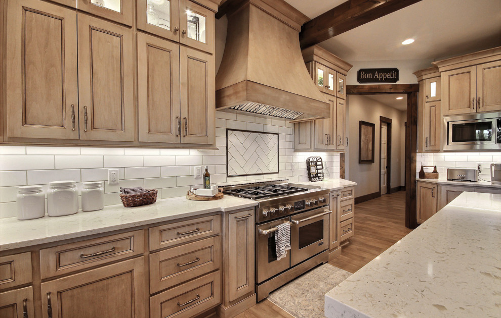 Exempel på ett mycket stort amerikanskt vit vitt kök, med en undermonterad diskho, luckor med infälld panel, skåp i slitet trä, bänkskiva i kvarts, vitt stänkskydd, stänkskydd i tunnelbanekakel, rostfria vitvaror, mörkt trägolv, en köksö och brunt golv