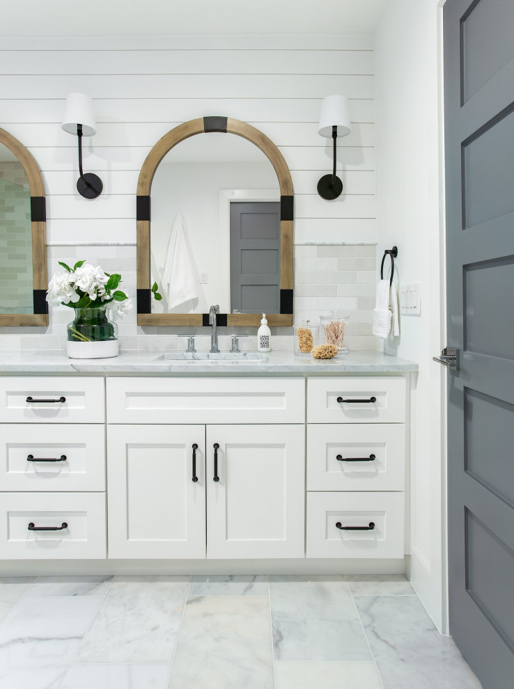 Example of a mid-sized beach style master white tile and marble tile marble floor, yellow floor and double-sink alcove shower design in Dallas with shaker cabinets, white cabinets, white walls, an undermount sink, marble countertops, a hinged shower door, white countertops and a built-in vanity