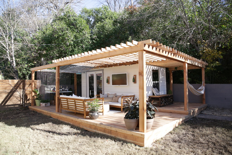 Photo of a small traditional backyard deck in Austin with a pergola.