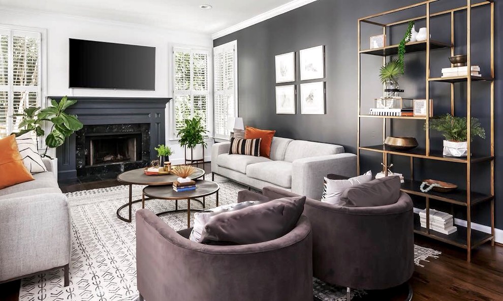 Design ideas for a mid-sized scandinavian open concept living room in Atlanta with dark hardwood floors, a standard fireplace, a wood fireplace surround, a wall-mounted tv, brown floor and black walls.