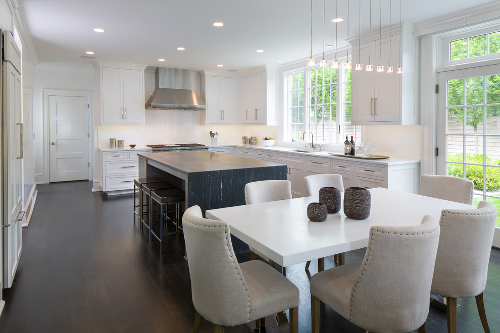 Photo of a mid-sized transitional l-shaped eat-in kitchen in New York with an undermount sink, recessed-panel cabinets, white cabinets, quartz benchtops, white splashback, ceramic splashback, stainless steel appliances, dark hardwood floors and with island.