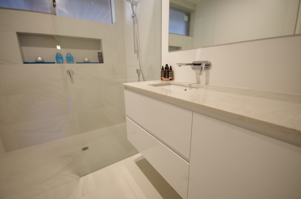 Photo of a contemporary master bathroom in Perth with furniture-like cabinets, white cabinets, an open shower, white tile, porcelain tile, white walls, porcelain floors, an undermount sink, engineered quartz benchtops, yellow floor, an open shower and white benchtops.
