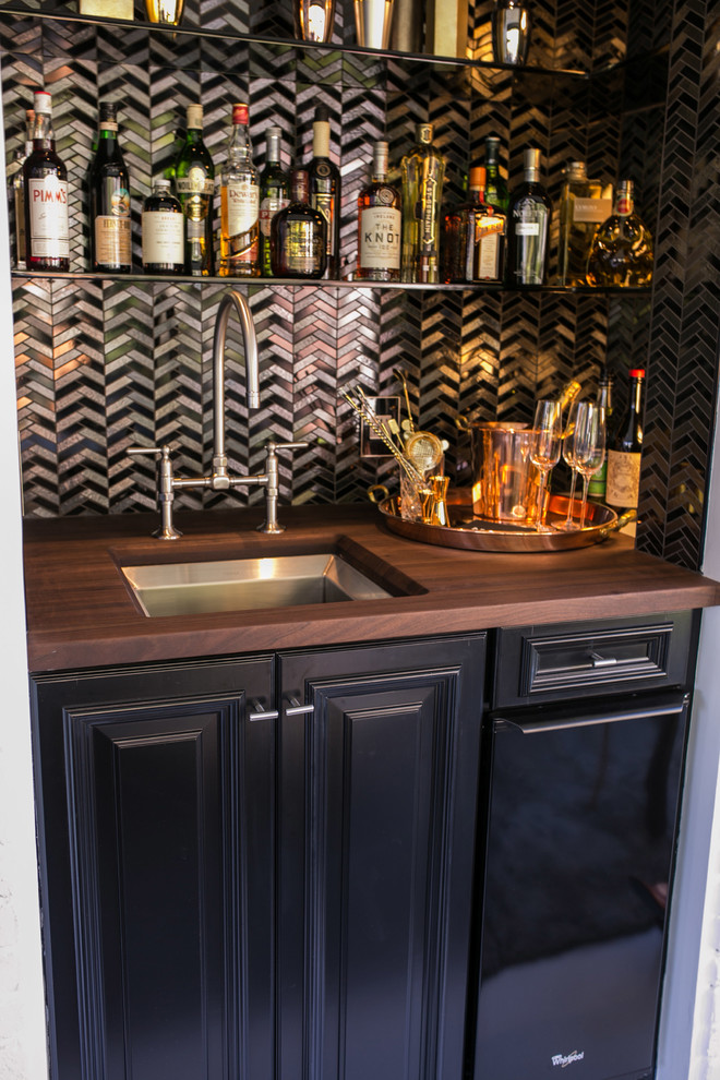 Photo of a mid-sized modern single-wall wet bar in San Francisco with an undermount sink, raised-panel cabinets, black cabinets, wood benchtops, multi-coloured splashback and metal splashback.