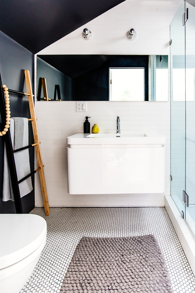 Small contemporary 3/4 bathroom in San Francisco with flat-panel cabinets, white cabinets, an alcove shower, a one-piece toilet, white tile, ceramic floors, black walls, a wall-mount sink and a hinged shower door.
