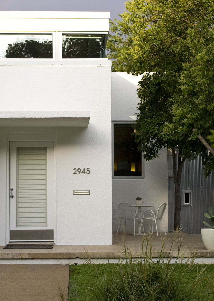 Photo of a midcentury entryway in Dallas with white walls, a single front door and a glass front door.