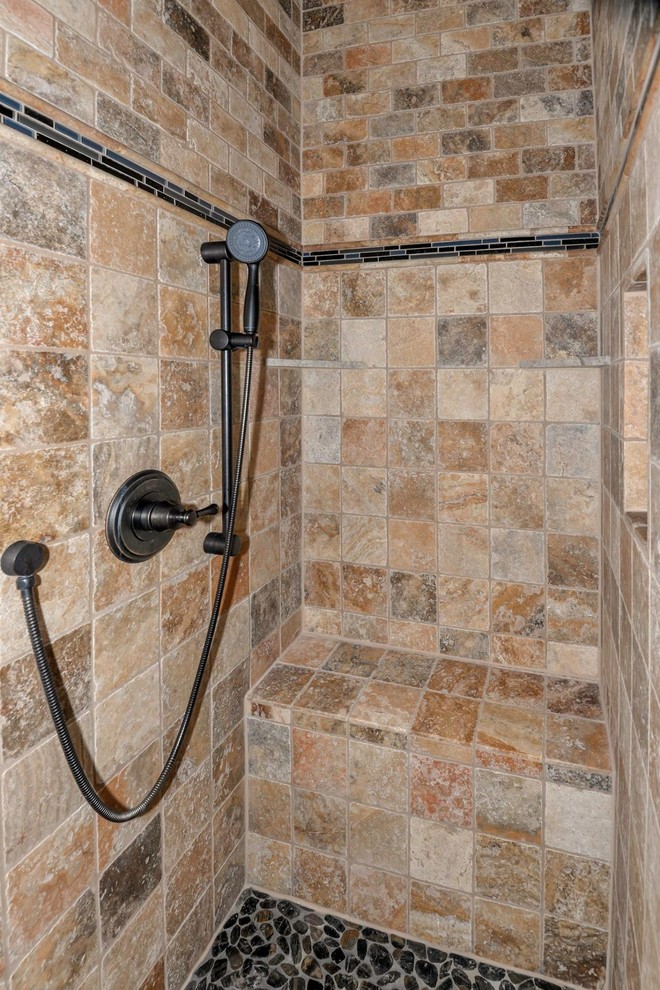 Design ideas for a mid-sized traditional master bathroom in Austin with dark wood cabinets, a freestanding tub, beige tile, ceramic tile, beige walls, pebble tile floors and granite benchtops.