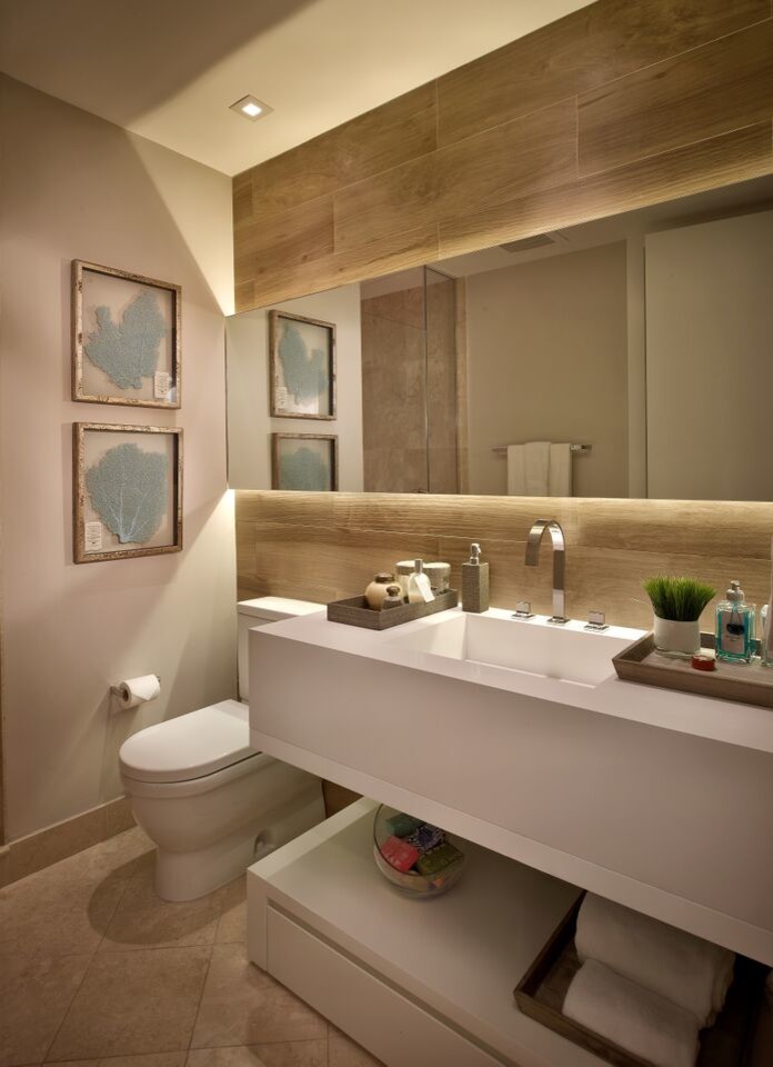 This is an example of a mid-sized contemporary powder room in Miami with an integrated sink, flat-panel cabinets, white cabinets, quartzite benchtops, a one-piece toilet, grey walls, marble floors and white benchtops.