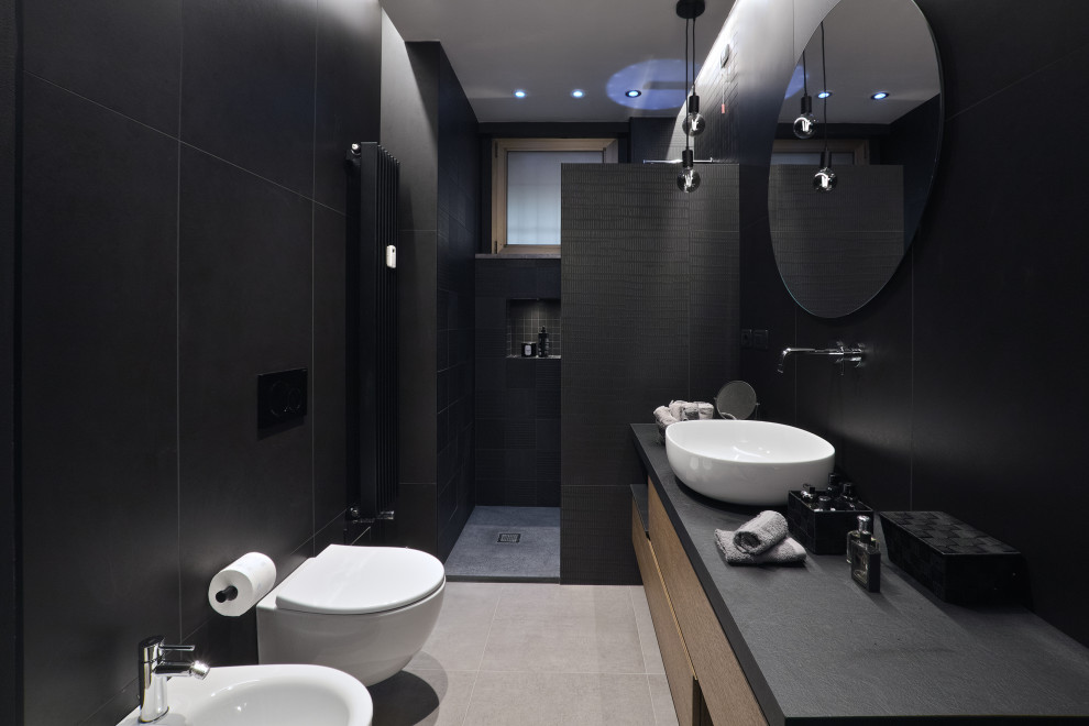 Inspiration för ett mellanstort funkis svart svart badrum med dusch, med släta luckor, skåp i ljust trä, en dusch i en alkov, en vägghängd toalettstol, svart kakel, porslinskakel, svarta väggar, klinkergolv i porslin, ett fristående handfat, bänkskiva i akrylsten, grått golv och med dusch som är öppen