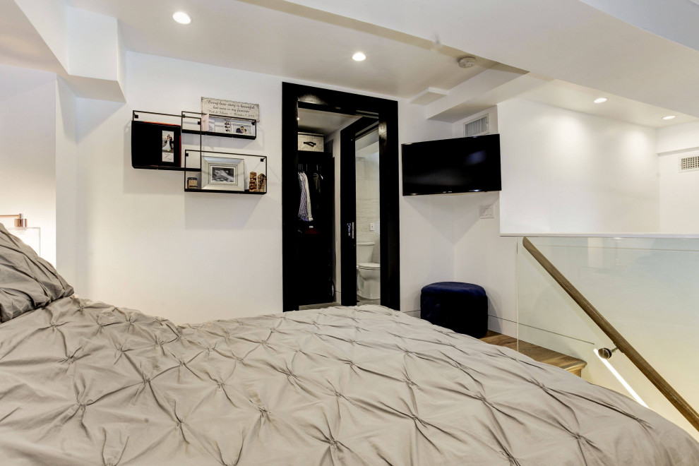 Exemple d'une chambre mansardée ou avec mezzanine moderne de taille moyenne avec un mur blanc, parquet clair, un sol beige et un plafond à caissons.