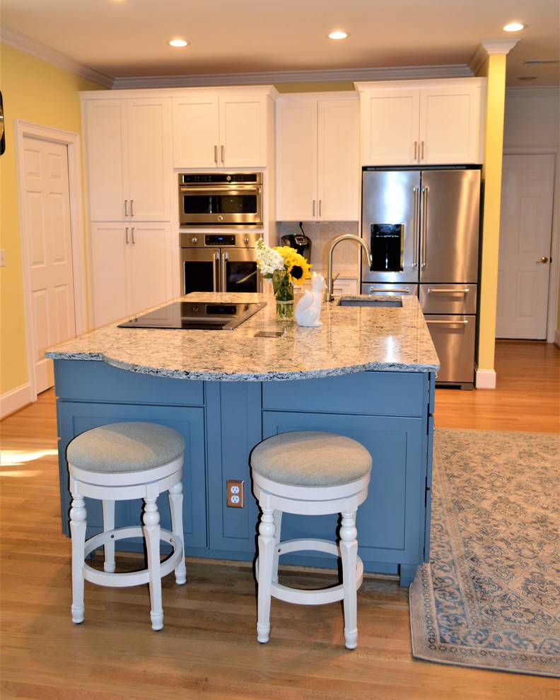 Design ideas for a mid-sized transitional u-shaped open plan kitchen in Wilmington with a single-bowl sink, shaker cabinets, blue cabinets, quartz benchtops, stainless steel appliances, light hardwood floors and multiple islands.