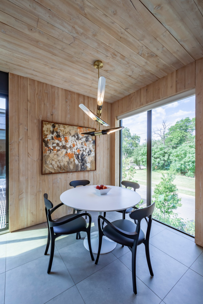 На фото: большая столовая в стиле модернизм с с кухонным уголком, коричневыми стенами, полом из керамической плитки, серым полом, деревянным потолком и панелями на части стены