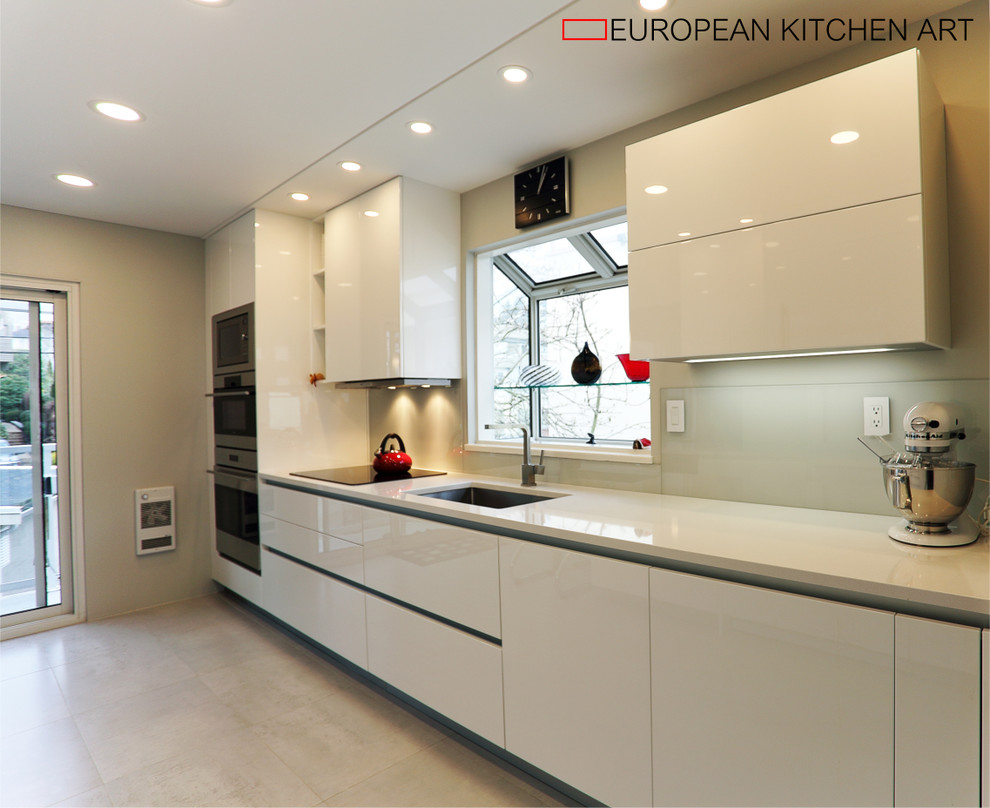 Inspiration for a mid-sized modern galley separate kitchen in Vancouver with an undermount sink, flat-panel cabinets, white cabinets, quartzite benchtops, grey splashback, glass sheet splashback, stainless steel appliances, porcelain floors and a peninsula.