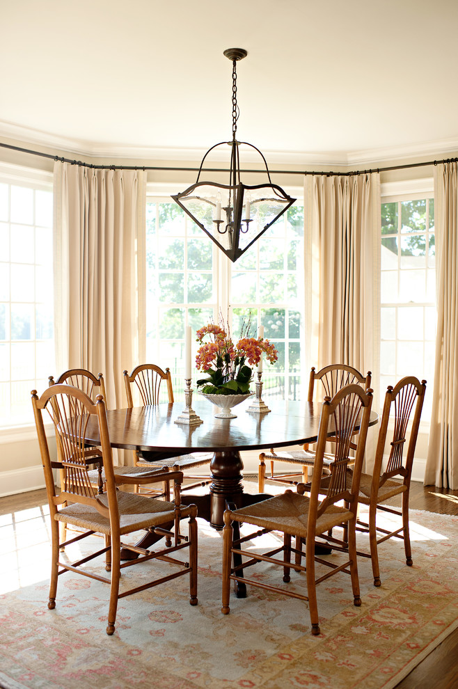 This is an example of a traditional dining room in Charlotte with beige walls and medium hardwood floors.