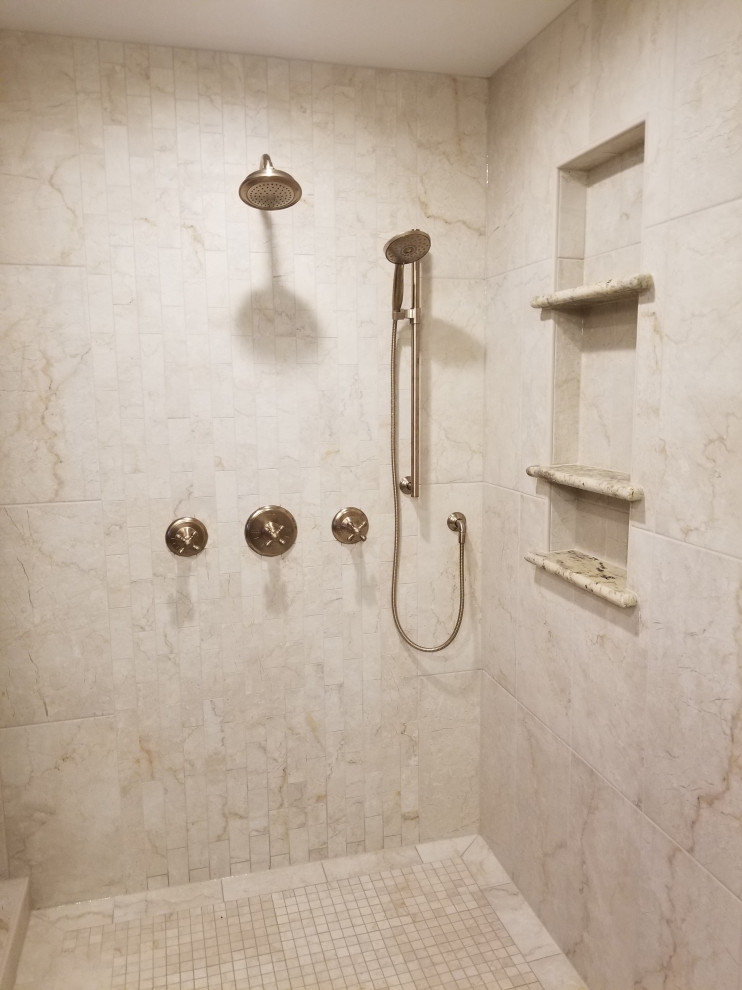 Cette photo montre une grande salle de bain principale montagne avec une douche d'angle, un carrelage beige, des carreaux de porcelaine, une cabine de douche à porte battante et meuble-lavabo encastré.